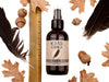 Wild Man Beard Wash - Raven scent in 4oz amber glass bottle. Shown next to ruler at about 6" tall. Black feathers, acorns and dried oak leaves surround. 