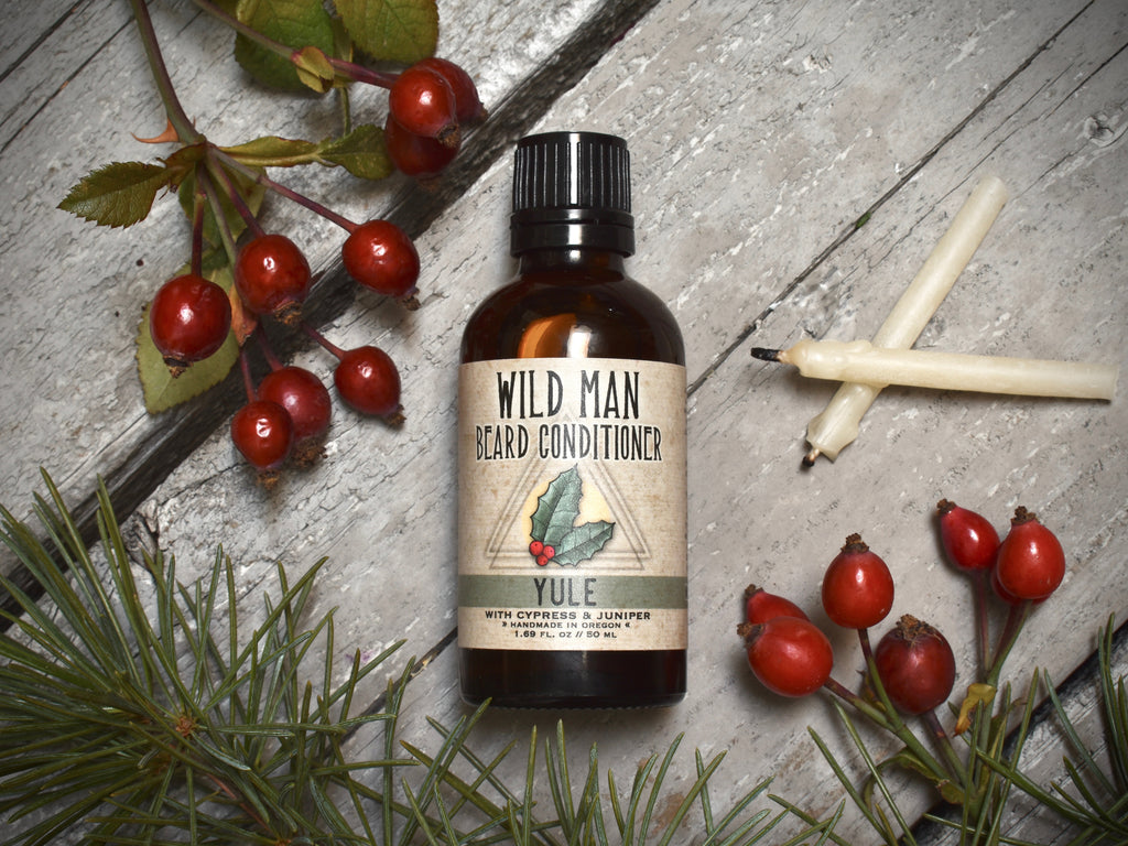 Wild Man Beard Oil Conditioner 50ml amber glass bottle in Yule scent. Rosehips and pine boughs surround.