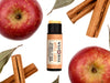 Apple Cider Natural Lip Balm in a biodegradable paper tube. The cap is off revealing a creamy orange balm. Apples and cinamon sticks surround.