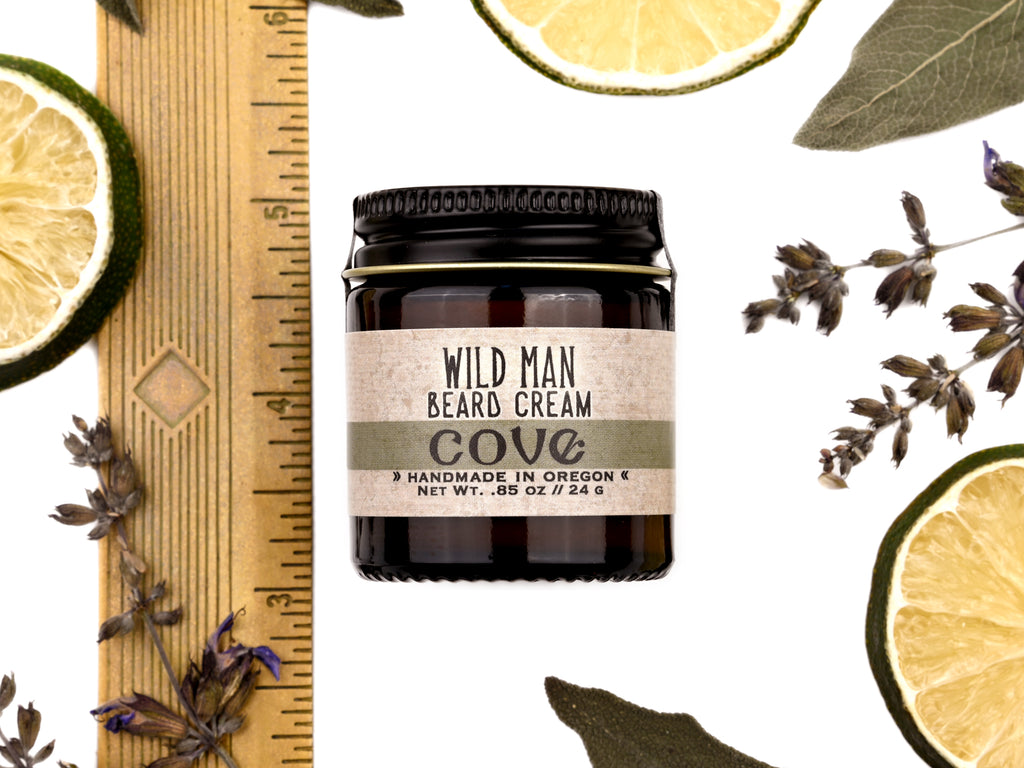 Wild Man Beard Cream Cove scent in 1oz amber jar. Shown next to ruler at about 2" tall. Lime slices and sage leaves surround.