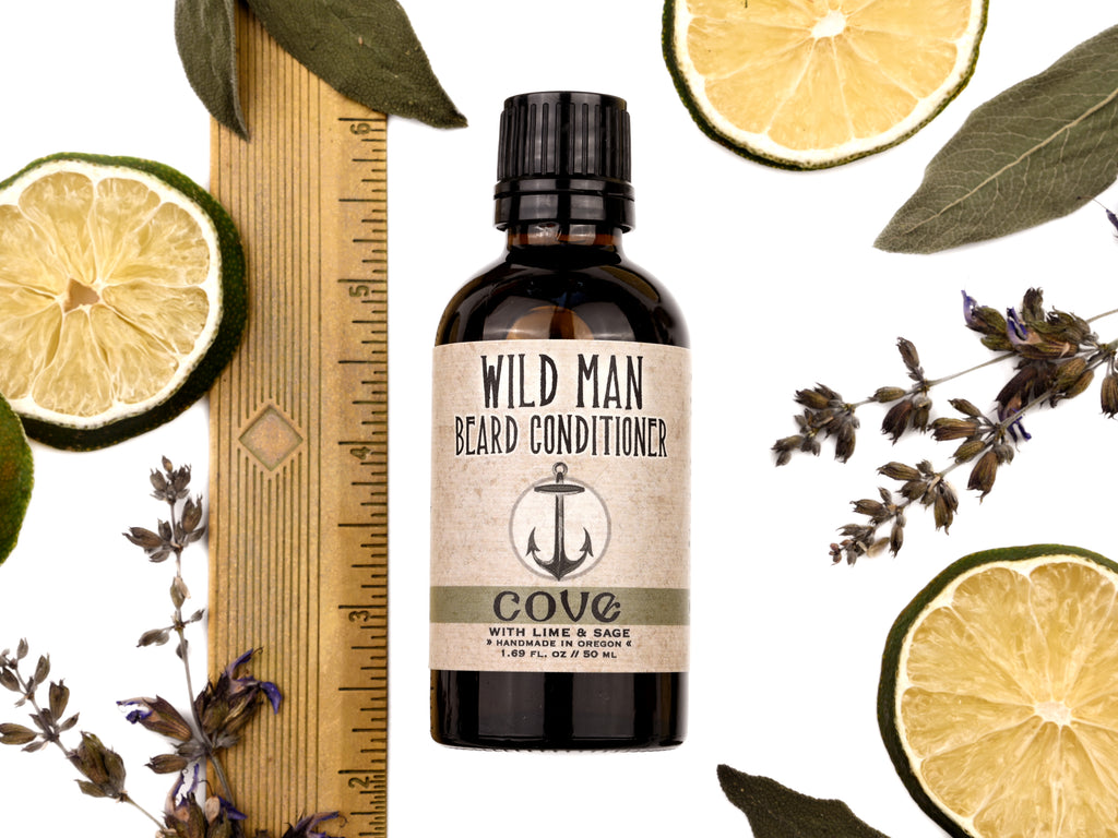 Wild Man Beard Oil Conditioner Cove scent in 50ml amber glass bottle. Shown next to ruler at about 4" tall. Lime slices and sage leaves surround.