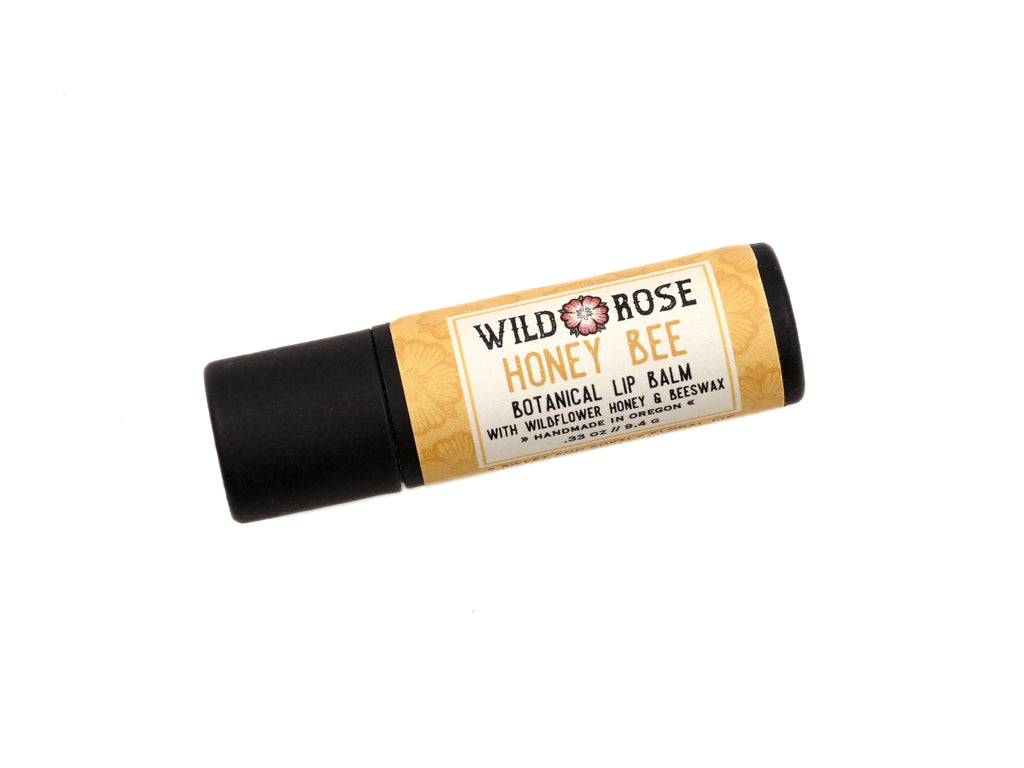 Honey Bee Natural Lip Balm in a biodegradable paper tube on a white background.