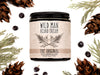 Wild Man Beard Cream in The Original scent shown in a 4oz amber glass jar. Cedar, fir cones and juniper berries surround.