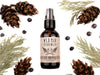 Wild Man Beard Wash in The Original scent shown in a 2oz amber glass bottle. Cedar, fir cones and juniper berries surround.