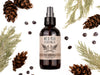 Wild Man Beard Wash in The Original scent shown in a 4oz amber glass bottle. Cedar, fir cones and juniper berries surround.