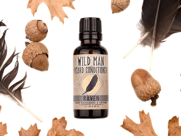 Wild Man Beard Oil Conditioner - Raven scent in 30ml amber glass bottle.Black feathers, acorns and dried oak leaves surround. 