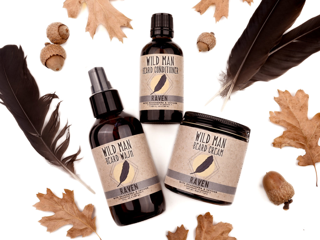 Wild Man beard care set in Raven scent with 50ml Beard Conditioner, 4oz Beard Wash and 4oz Beard Cream. Black feathers, acorns and dried oak leaves surround.