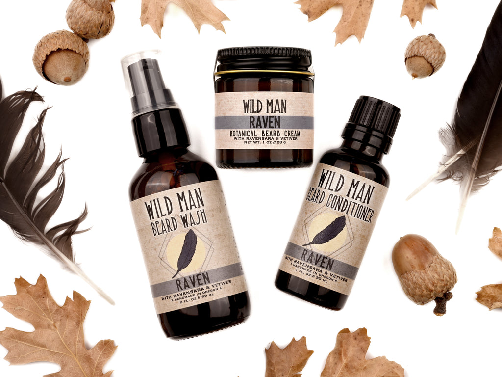 Wild Man beard care set in Raven scent with 30ml Beard Conditioner, 2oz Beard Wash and 1oz Beard Cream. Black feathers, acorns and dried oak leaves surround.
