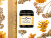 Renewal Healing Salve in a 4oz amber glass jar with metal lid. Shown near a ruler at about 2" tall.  Dried yarrow and calendula surround.