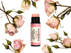 Rosebud Natural Lip Balm in a biodegradable paper tube with cap off revealing a naturally pigmented creamy pink balm. Dried roses surround.