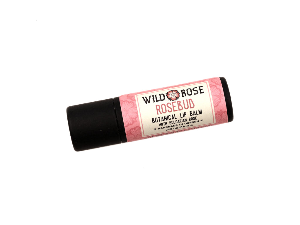 Rosebud Natural Lip Balm in a biodegradable paper tube on a white background.