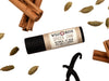 Spiced Chai Natural Lip Balm in a biodegradable paper tube. Cinnamon stick, cardamom and vanilla pods surround.