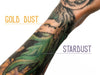 Biodegradable Glitter Stix product shown applied to a tattooed arm. Gold Dust and Stardust colors shown.