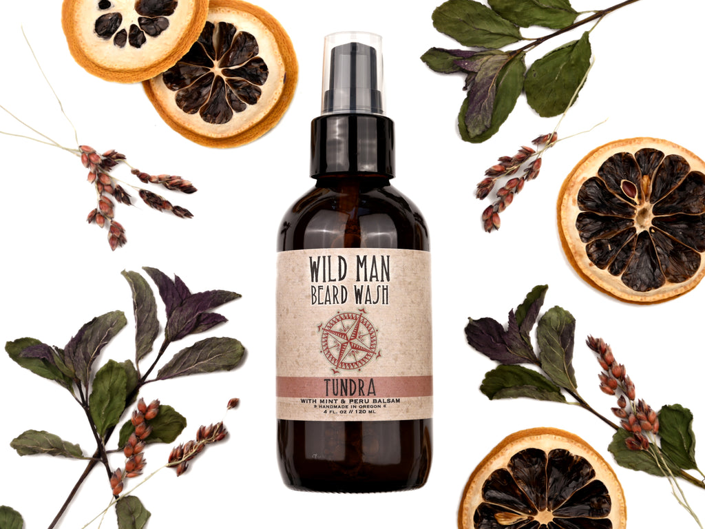 Wild Man Beard Wash Tundra scent in 4oz amber glass bottle. Lemon slices and peppermint leaves surround.