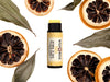 Yuzu Lip Balm in a biodegradable paper tube. The cap is removed revealing a creamy yellow lip balm. Dried lemon slices and leaves surround.