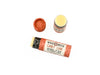 Candy Cane Natural Lip Balm in a biodegradable paper tube on a white background. The cap is removed, revealing a creamy white balm. 