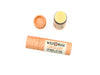Wild Rose Cantaloupe Botanical Lip Balm in a biodegradable paper tube shown on a white background. The cap is removed revealing a creamy off-white balm.