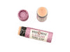 Elderberry Natural Lip Balm in a biodegradable paper tube on a white background. The cap is off revealing a creamy, light pink balm.