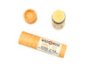 Honey Bee Natural Lip Balm from Wild Rose in a biodegradable paper tube on a white background. The cap is removed, revealing a creamy yellow balm.