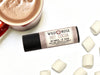 Hot Cocoa Natural Lip Balm in a biodegradable paper tube. Hot cocoa and marshmallows surround.