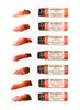 Eight Wild Rose Botanical Lip & Cheek Tint tubes arranged vertically on a white background, each paired with a corresponding textured color smear showing the tints shade, including Peach, Roseberry, Raspberry, Cherry Vanilla, Mocha, Blood Orange, and Mandarin Fig.