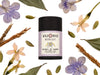 Moonlight Dry Shampoo in biodegradable paper shaker tube with jasmine, vetiver, cardamom and purple flowers surrounding.
