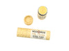 Wild Rose Piña Colada Botanical Lip Balm in a biodegradable tube on a white background. The cap is off, revealing a creamy yellow balm.