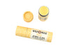 Wild Rose Yuzu Botanical Lip Balm shown with its yellow patterned cardboard tube, alongside the cap and an open tube displaying the yellow balm, on a white background.