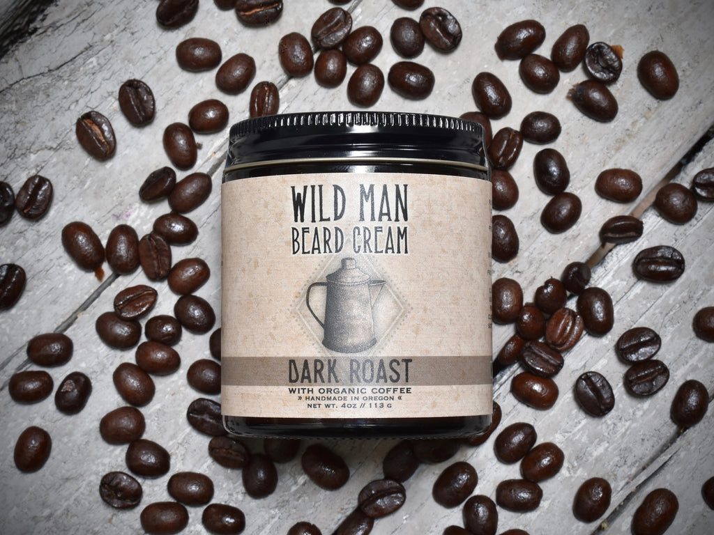 Wild Man Beard Softening Cream 4oz amber glass jar in Dark Roast scent. Coffee beans surround.