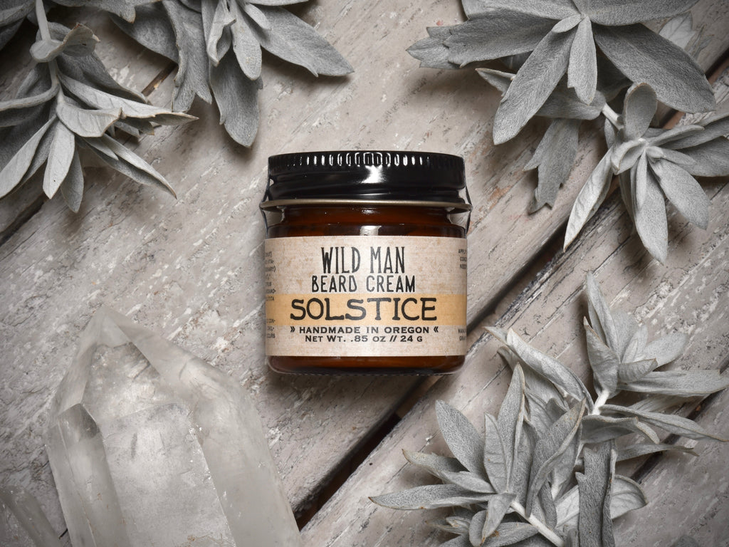 Wild Man Beard Softening Cream Solstice in 1oz amber glass jar. Mugwort leaves and quartz crystals surround.