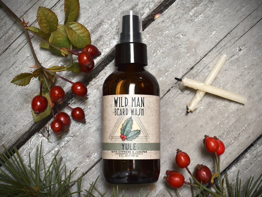 Wild Man Beard Wash 4oz amber glass bottle in Yule scent. Rosehips and pine boughs surround.