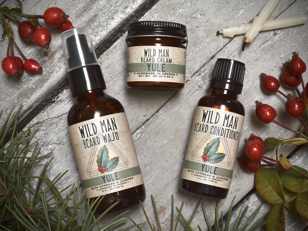 Wild Man beard care set in Yule scent with 30ml Beard Conditioner, 2oz Beard Wash and 1oz Beard Cream. Rosehips and pine boughs surround.